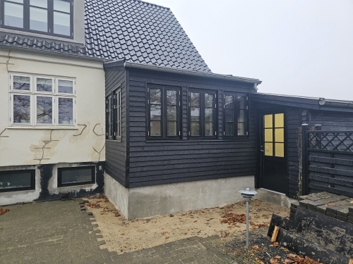 Sort tilbygning i træ